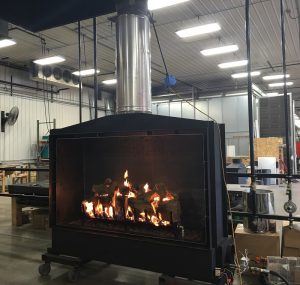 large open gas fireplace with log set being tested