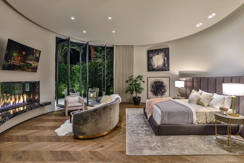 linear fireplace with TV above in master bedroom