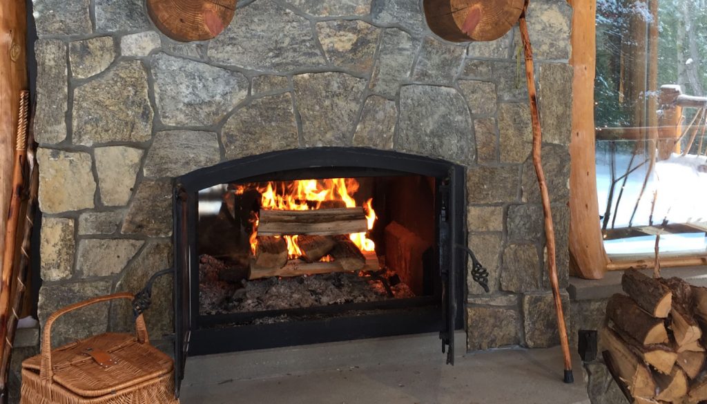 indoor outdoor wood burning fireplace with open doors