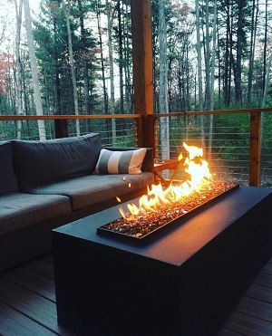 custom outdoor fire table with no glass on deck of private residence