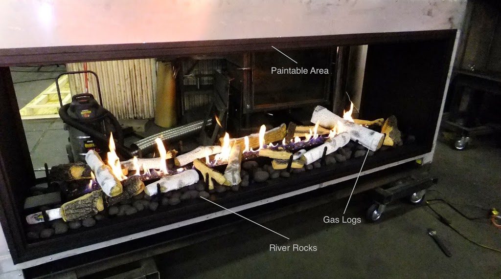 acucraft see through gas fireplace with driftwood logs and river rocks being tested