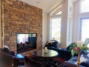 indoor outdoor see through gas fireplace with log set in living room