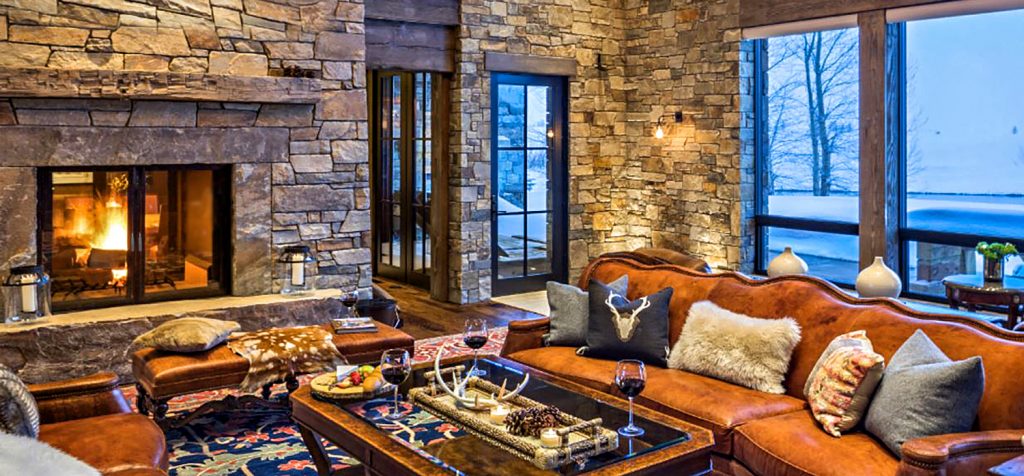 A living room with leather couches and a see through fireplace