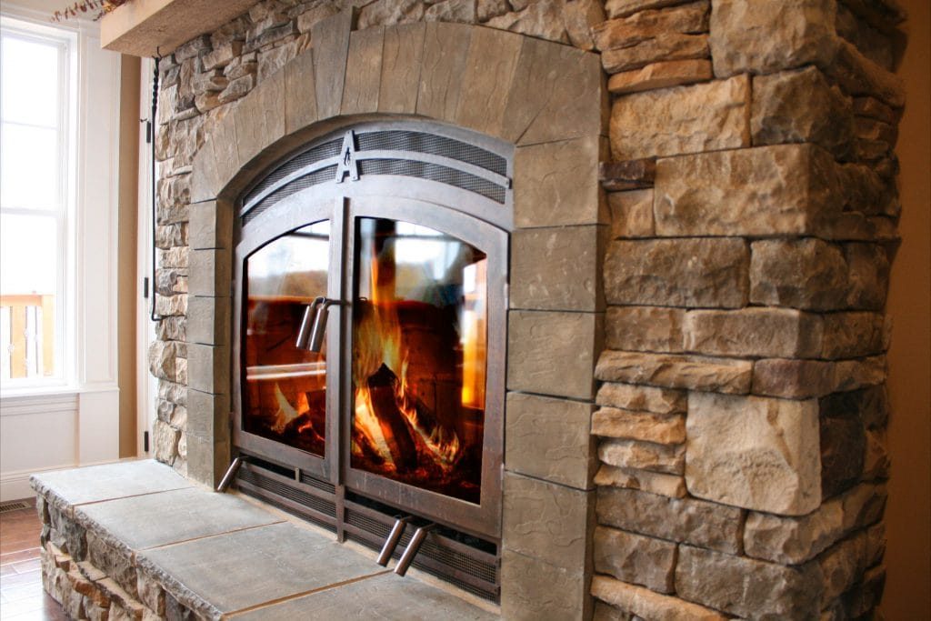 a stone wood-burning fireplace in a cabin