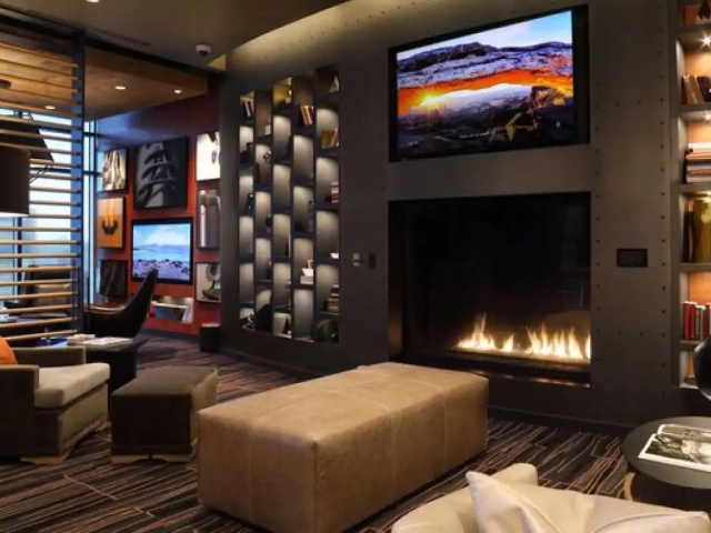 large square gas fireplace with industrial finish in quiet lounge in luxury apartment complex