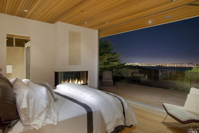 see through gas fireplace between bedroom and bathroom overlooking san Francisco bay