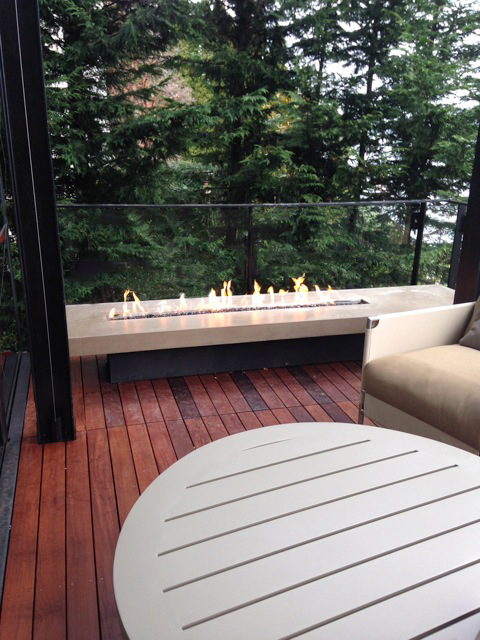 outdoor linear glass fireplace on deck of private residence