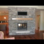 see through wood burning fireplace dividing kitchen and living room