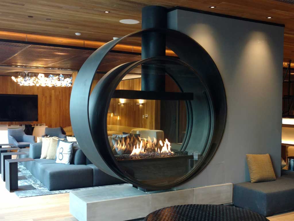 custom upright circular gas fireplace in hotel lobby