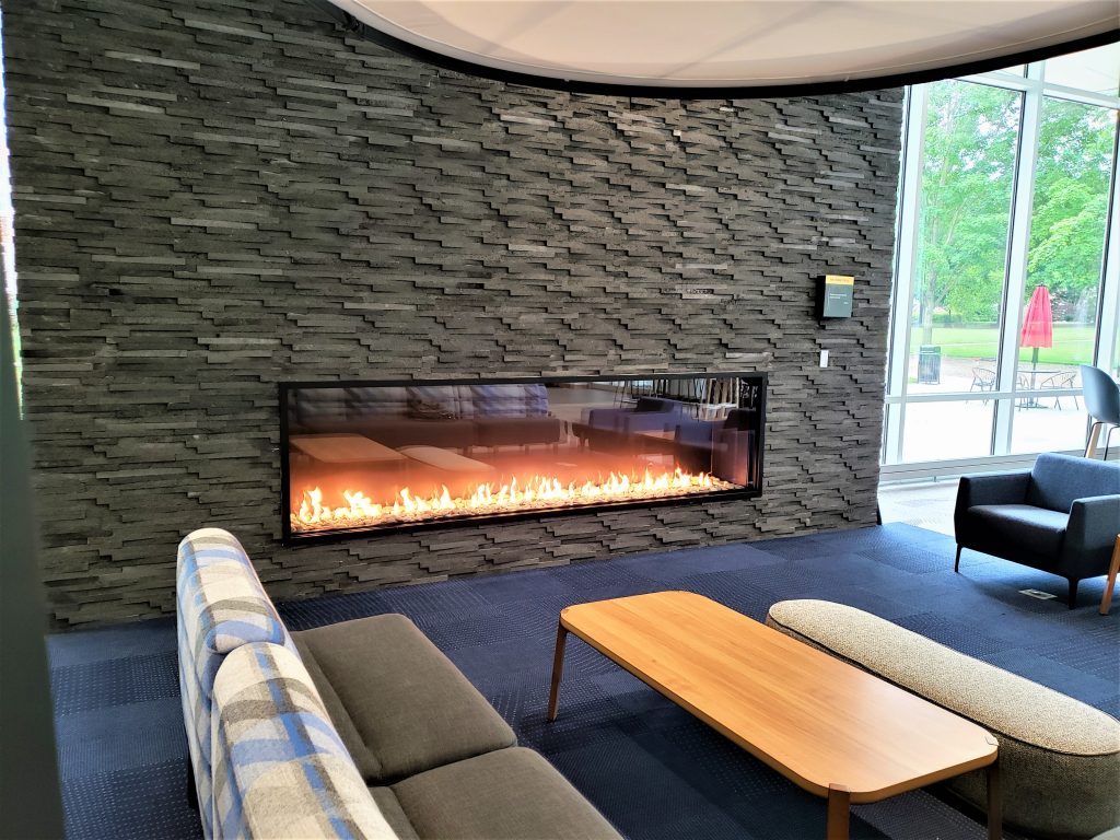 Acucraft Custom Linear Single Sided Gas Fireplace with Matte Black Frame Black Glass Media and Light Gray Stones (1)