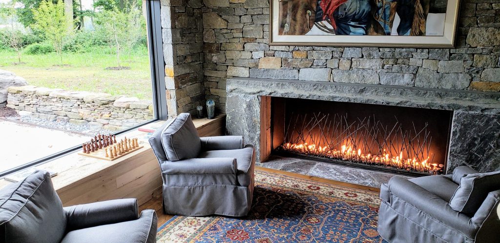 A living room with a single sided fireplace and a game of chess