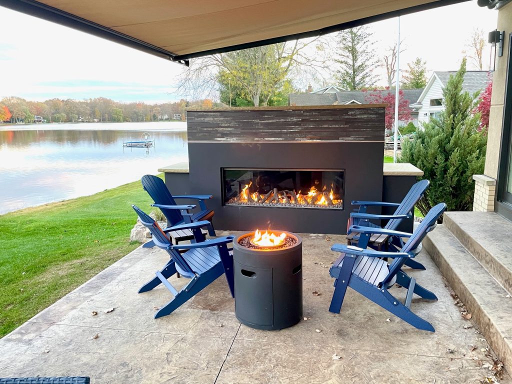 outdoor fireplace on a patio by a lake