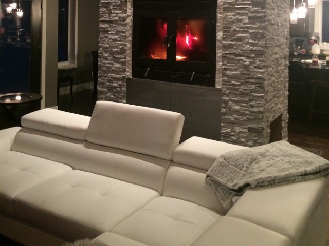 see through wood burning fireplace with rectangular front and doors and white rock surround