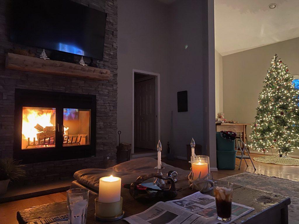 A living room with candles and a wood-burning fireplace