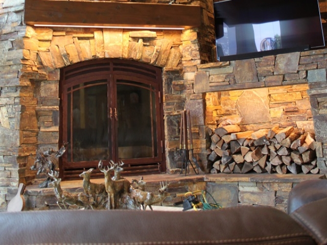 large single sided wood burning fireplace in rustic living room
