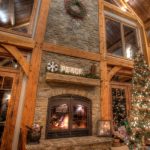 see through indoor outdoor wood fireplace with christmas tree