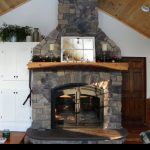 single sided wood burning fireplace with stone surround in living room