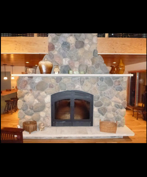 single sided wood burning fireplace with stone surround