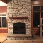 single sided wood burning fireplace with light stone surround