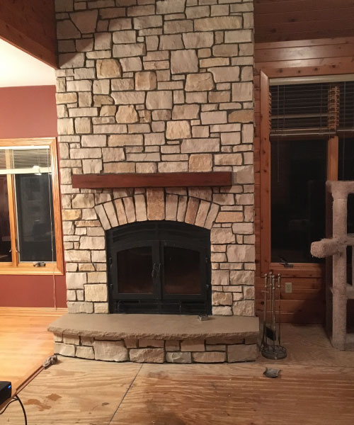 single sided wood burning fireplace with light stone surround