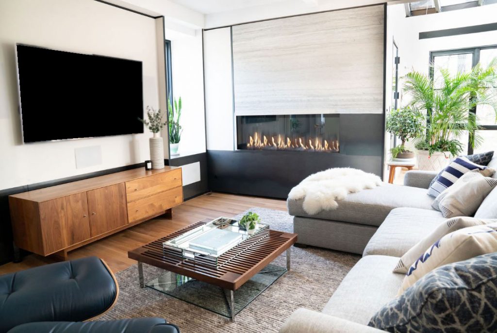 A living room with wood features and a single sided fireplace