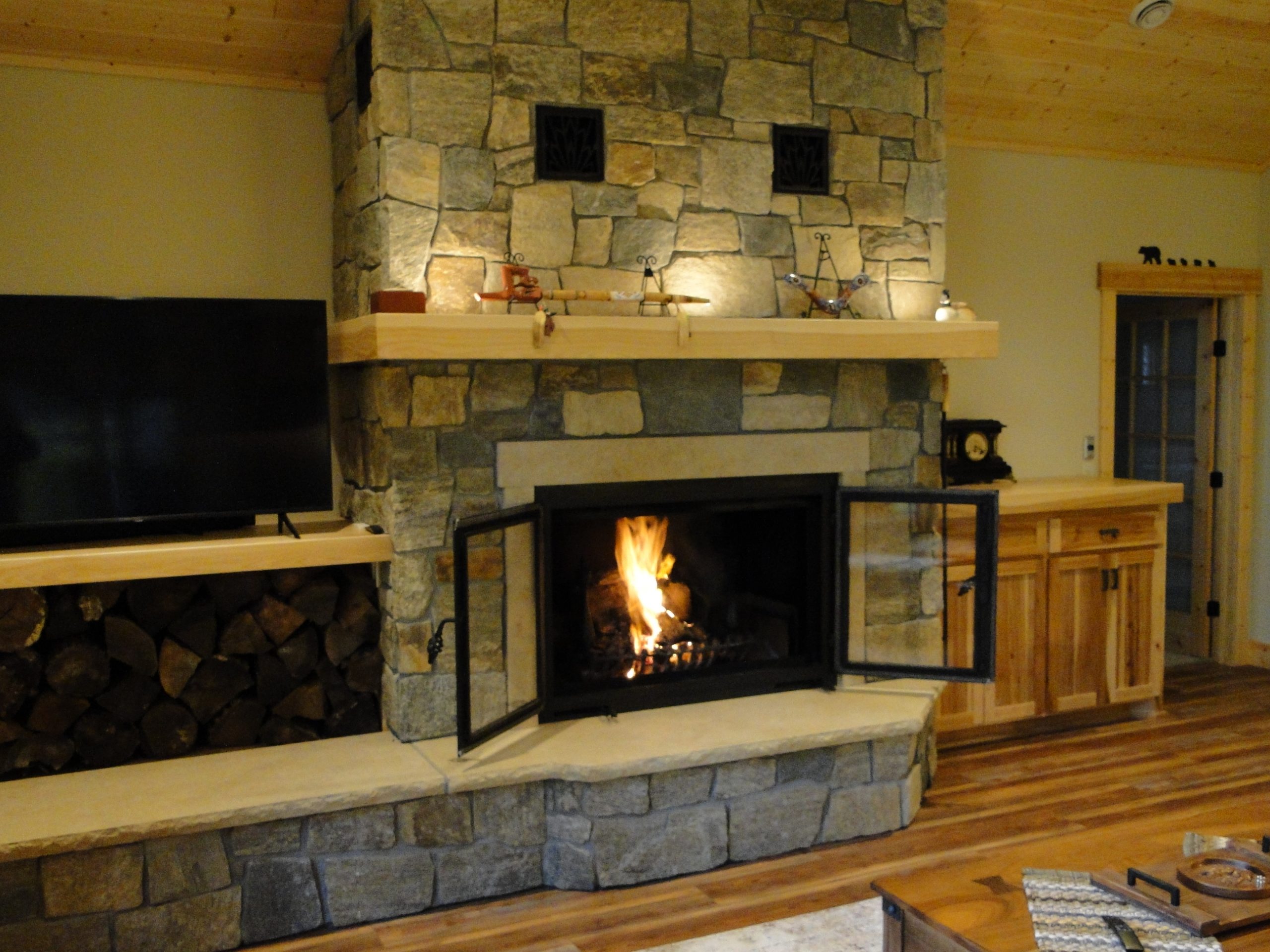 A single sided wood burning fireplace with open rectangle front doors 