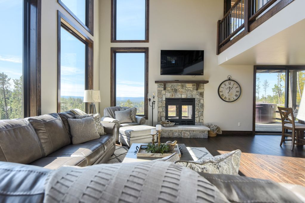 a living room with an indoor outdoor fireplace and large clock decoration on the wall