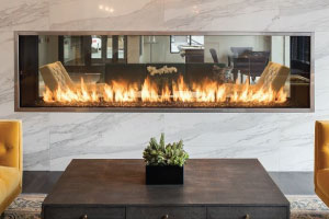 see through gas linear fireplace in apartment lobby