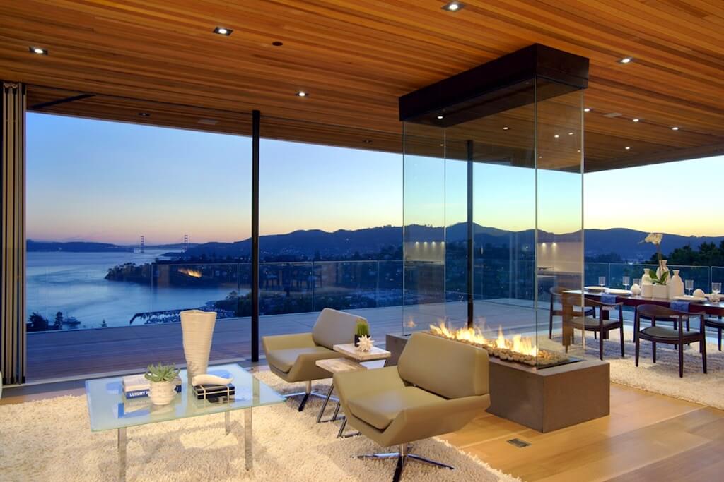 A living room with a fuzzy rug and four sided fireplace