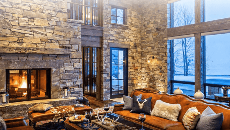 Earth tone furniture and interior decoration surrounded by large stonework walls