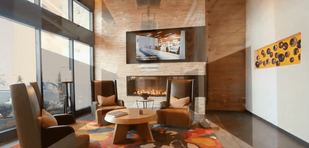 Warm color home interior with a TV mounted on the wall and a panoramic fireplace