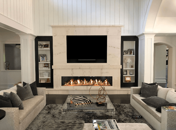 Beautiful living room centered around a marble entertainment center over a linear fireplace