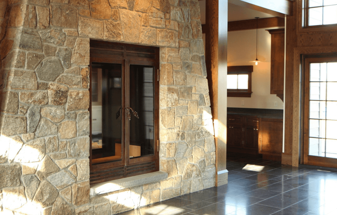 wood burning fireplace with stonework surrounding it