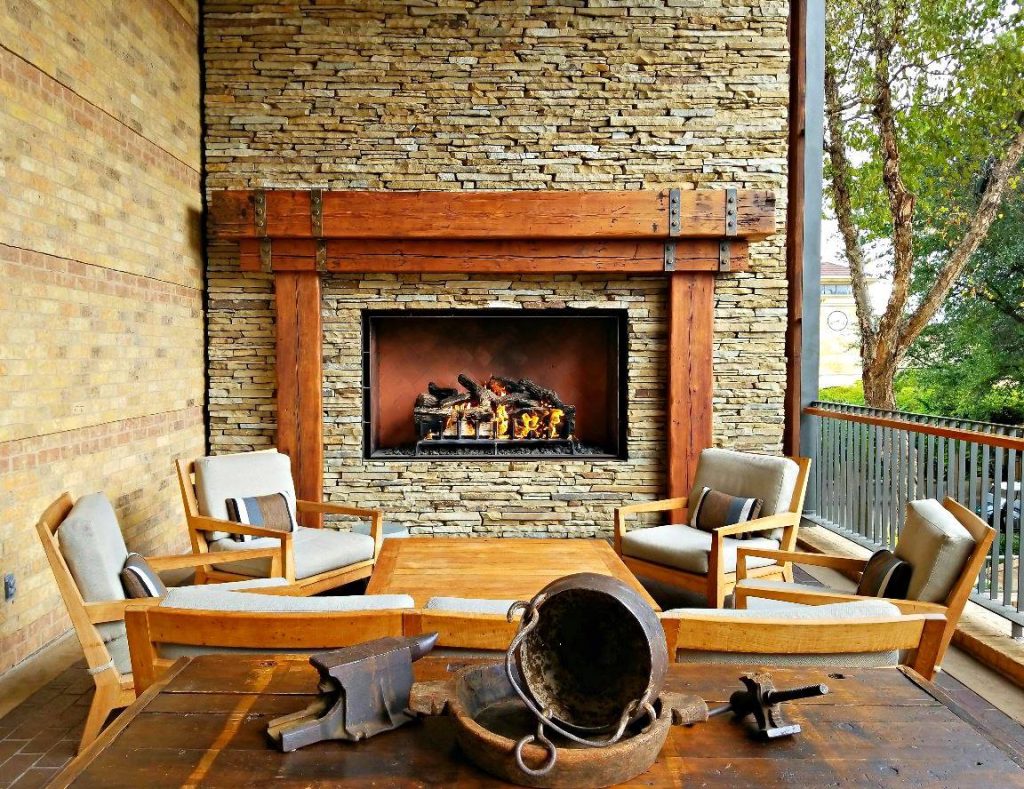 an outdoor gas fireplace with log set