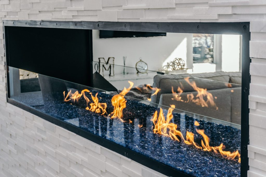 a linear double sided fireplace with partial safety glass barrier