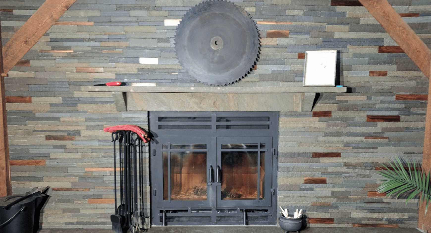 Iron door fireplace with stacked stone and stone mantle