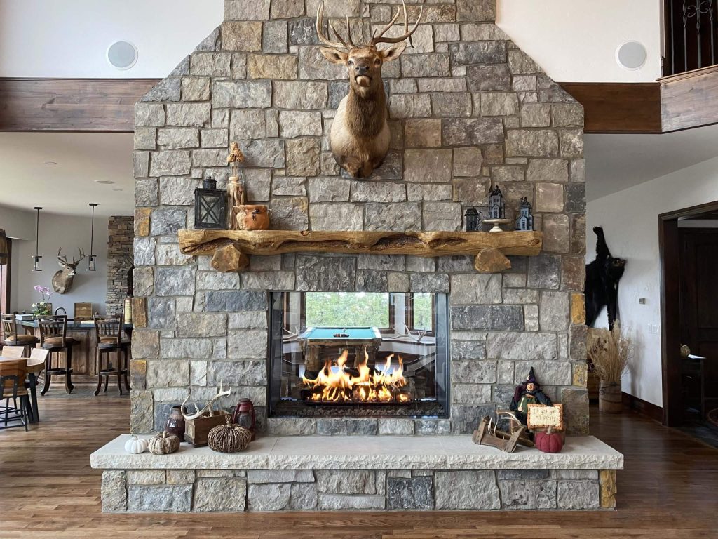 a see-through fireplace with a wood mantel