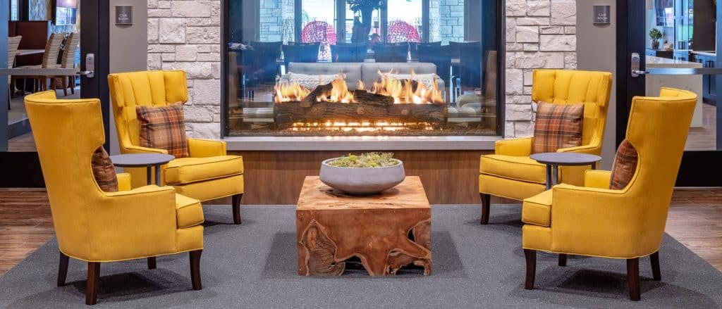double sided gas fireplace with logs in modern living room