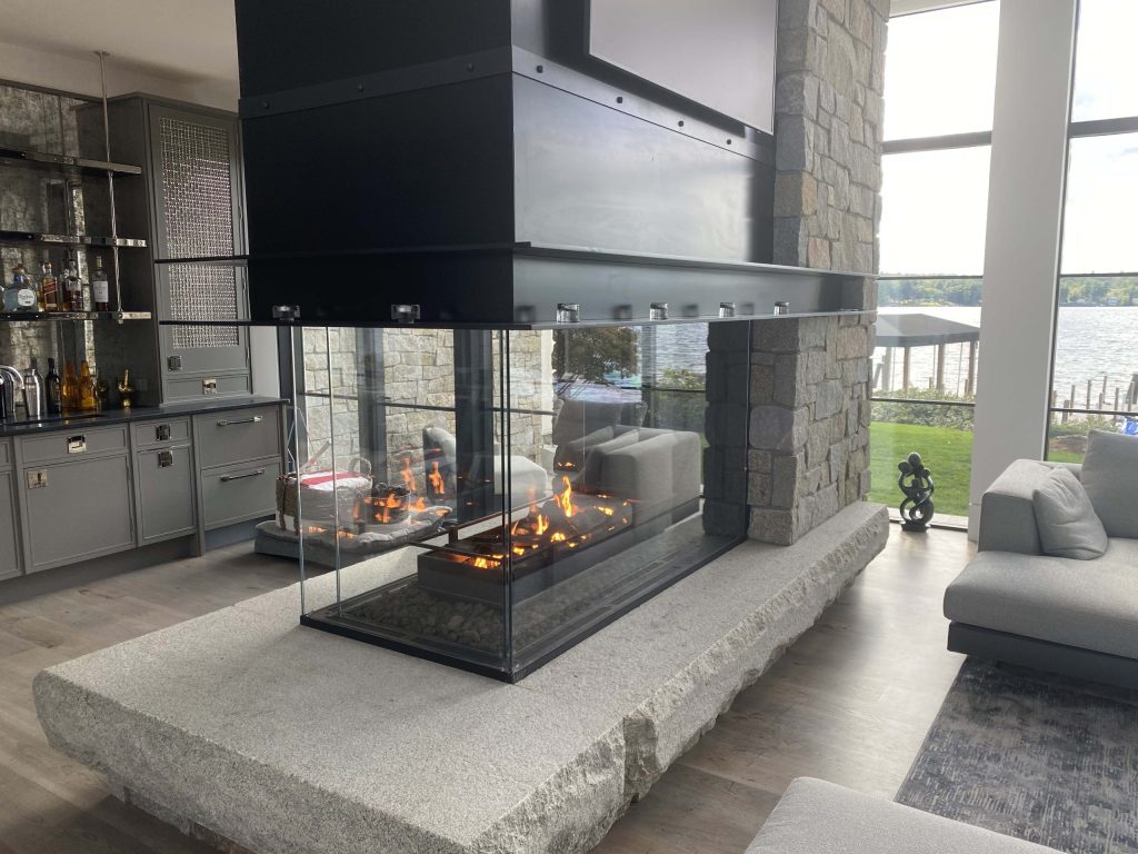 Modern living area with a custom peninsula gas fireplace featuring a log set and lava rock.