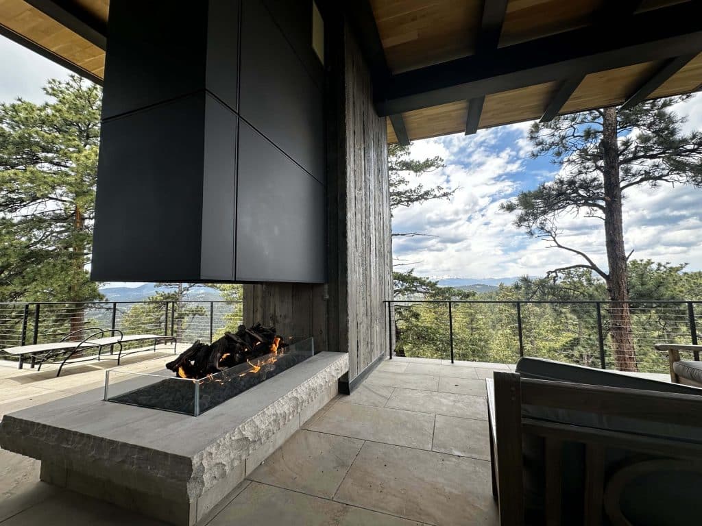 luxury 3 sided open view gas fireplace with logs in modern colorado home overlooking the mountains