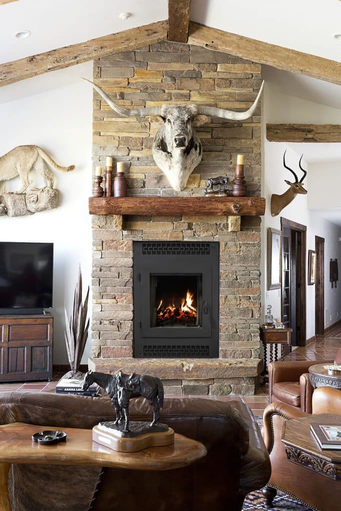 rustic living room with stone fireplace and exposed beams