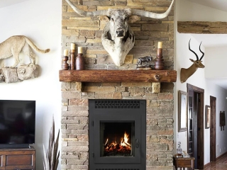rustic living room with stone fireplace and exposed beams