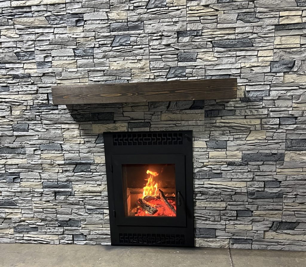 front facing wood fireplace with gray stacked faux stone finish