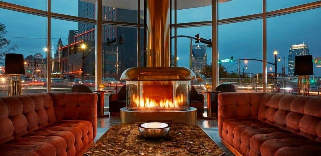 an oval fireplace with couches by it in a bar lounge