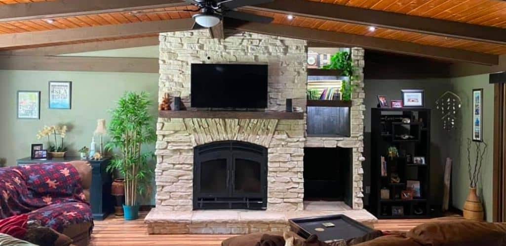 a wood burning fireplace remodeled with a white stone surround