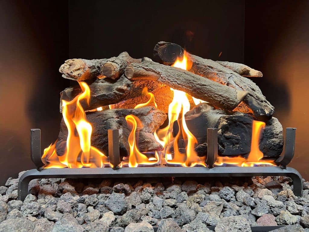 a gas fireplace with a charred oak log set