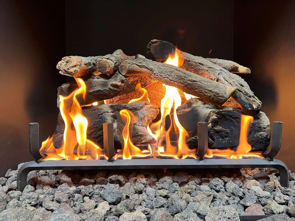 a gas fireplace with a charred oak log set