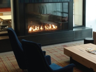 a commercial business lounge with a large cozy gas fireplace