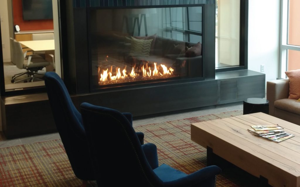 a commercial business lounge with a large cozy gas fireplace