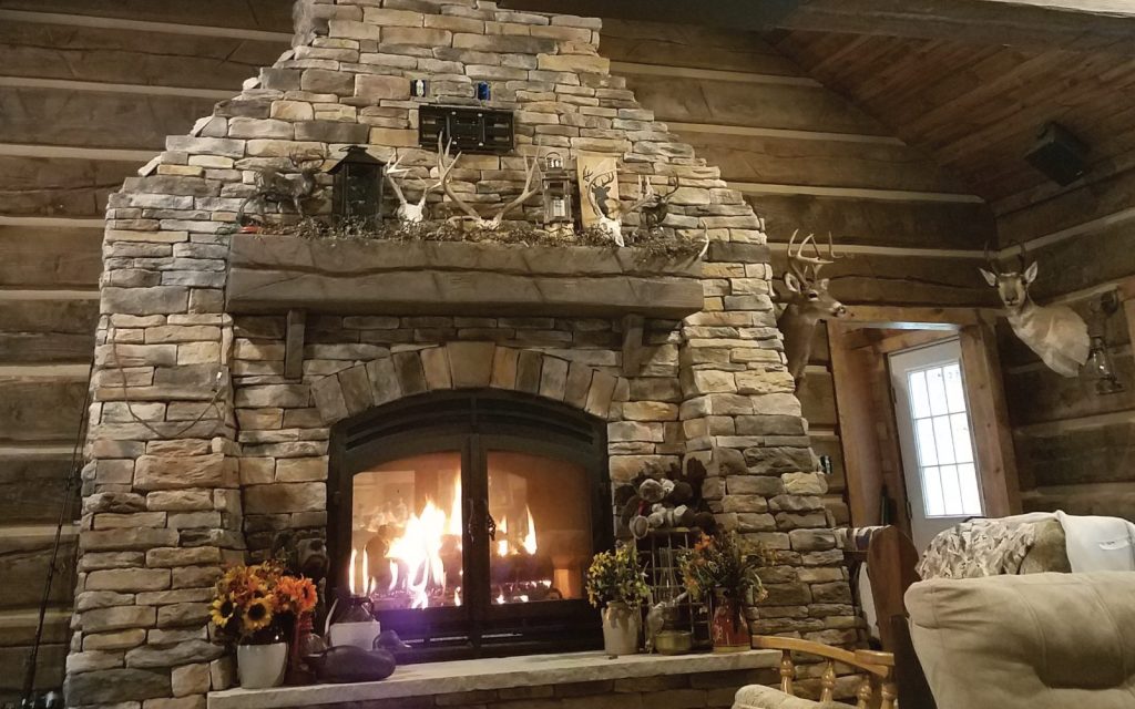 a 2 sided wood burning fireplace in a rustic cabin